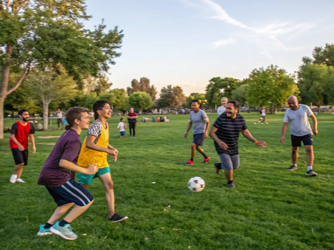 A vibrant image of diverse community members engaging in a friendly soccer match in a local park, smiling and enjoying the activity.